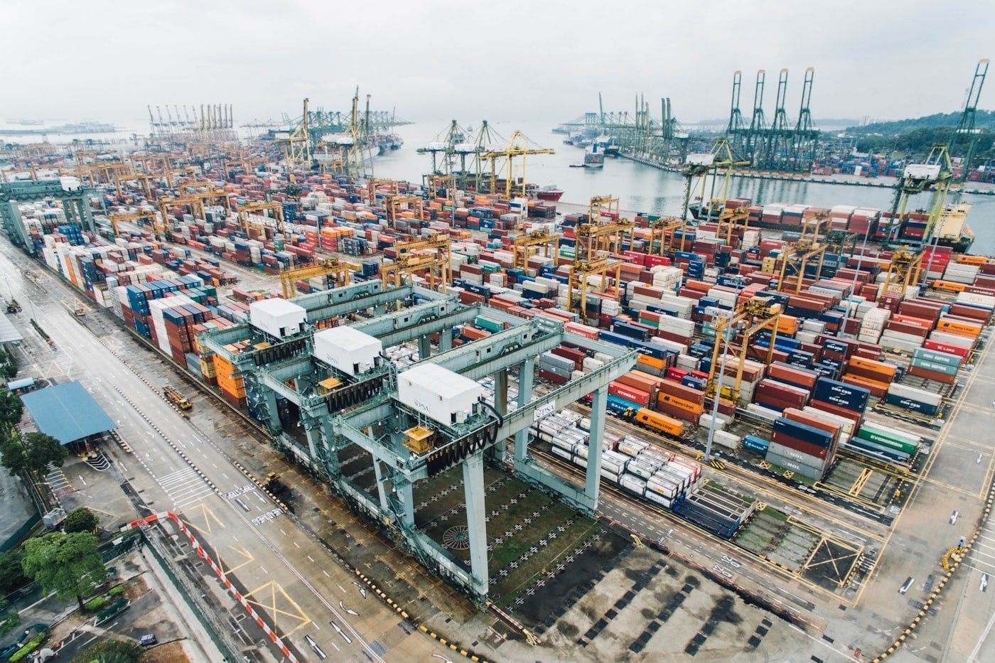 Aerial view of a container terminal with cranes and stacked shipping containers